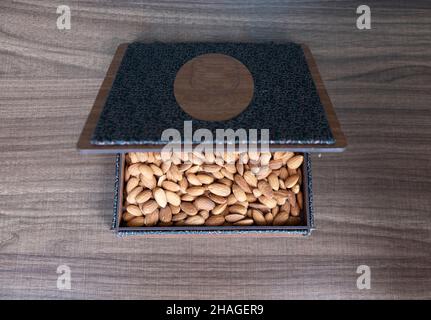 amandes, amandes brutes en boîte décorative en bois sur table en bois, gros plan par le dessus Banque D'Images