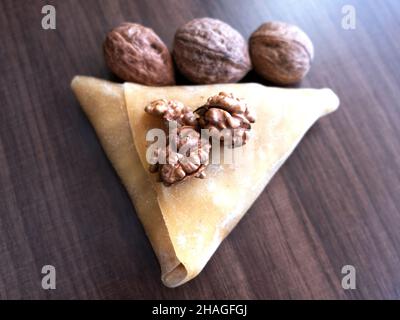 pestil de raisin, noix sous la pâte triangulaire sur la table en bois gros plan, pestil turc, en-cas sain Banque D'Images