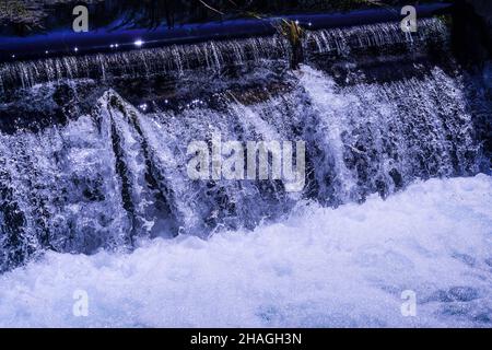 Photographie à grande vitesse (congélation par action) d'eau qui coule sur une corniche Banque D'Images