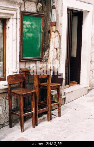 Table haute en bois et deux chaises près du mur d'un petit bar dans la rue Banque D'Images