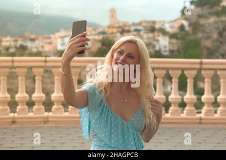 Femme blonde gracieuse dans ses 40s prises de selfies Banque D'Images