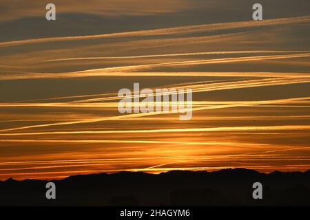 Le ciel de l'aube avec des pistes de vapeur d'avion croise en traversant montrant l'activité occupée de l'avion au-dessus du nord de l'Espagne Banque D'Images