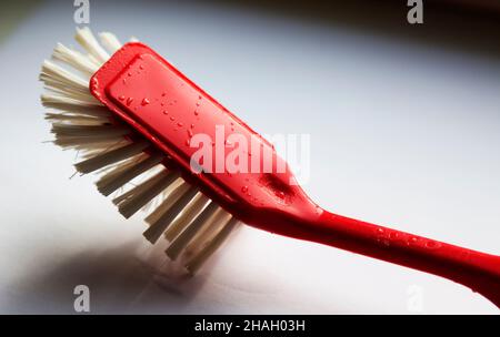 Umea, Norrland Suède - 10 juin 2019 : brosse à vaisselle rouge utilisée dans la fenêtre de la cuisine Banque D'Images