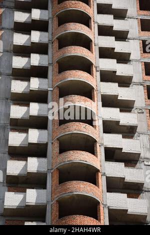 Gratte-ciel non fini de grande hauteur avec murs en briques, balcons et fenêtres non vitrées Banque D'Images
