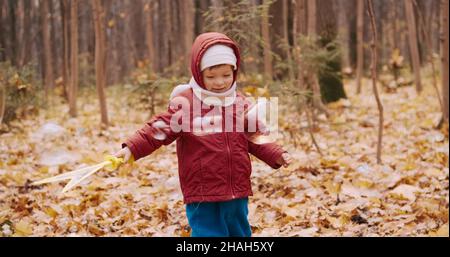 Petite fille soufflant des bulles de savon dans un parc d'automne Banque D'Images