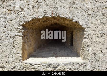 Un embrasure pour la prise de vue dans l'épais mur d'une ancienne forteresse ou d'un château.Recouvert de pierre rugueuse Banque D'Images