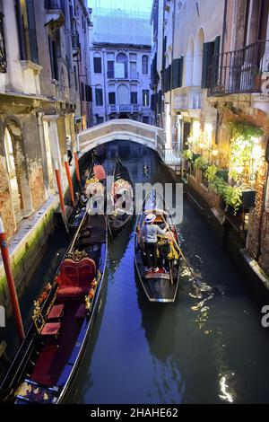 Plusieurs bateaux avec des gondoliers se reposent après le travail dans la soirée entre les bâtiments historiques sur l'eau, Venise, Italie.10.16.2019 Banque D'Images