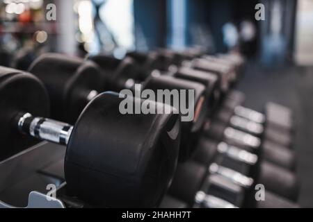 Des rangées d'haltères sur le rack dans la salle de gym Banque D'Images