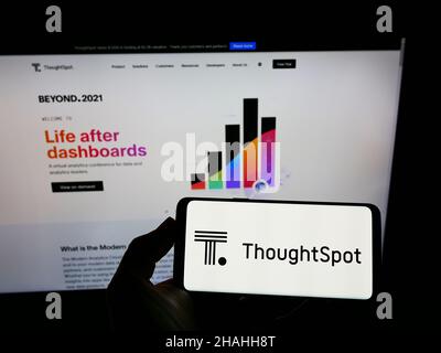 Personne tenant un smartphone avec le logo de la société américaine de logiciel analytique ThoughtSpot Inc. À l'écran devant le site Web.Mise au point sur l'affichage du téléphone. Banque D'Images
