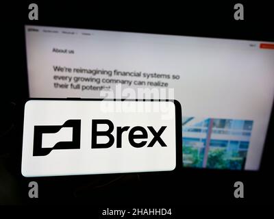 Personne tenant un téléphone portable avec le logo de la société américaine de technologie financière Brex Inc. À l'écran en face de la page Web.Mise au point sur l'affichage du téléphone. Banque D'Images