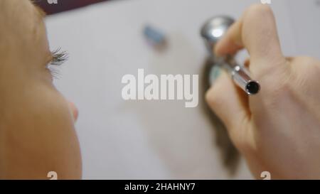 Une artiste apprend à peindre avec un aérographe avec du colorant acrylique, du papier et du chevalet.Concept art moderne, aérographe, aérographie, graffiti, aérosol Banque D'Images