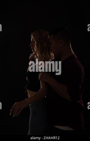 Femme et homme asiatiques dansant à la musique dans le noir Banque D'Images