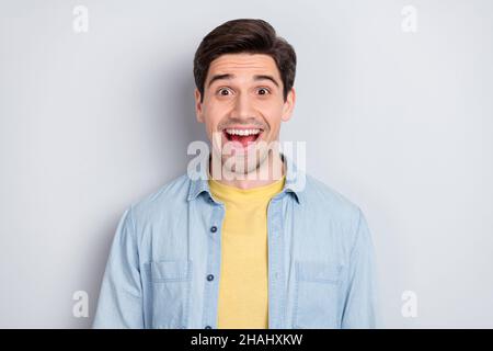 Photo de doux charmant impressionné jeune gars porter jeans chemise sourire bouche ouverte isolé couleur grise fond Banque D'Images