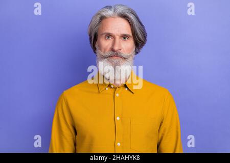 Portrait de contenu attrayant sérieux gris-cheveux homme portant une chemise classique isolé sur fond violet vif de couleur violet Banque D'Images