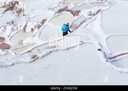 Salines à Salinas.Un ouvrier porte du sel le long des terrasses. Banque D'Images