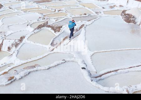 Salines à Salinas.Un ouvrier porte du sel le long des terrasses. Banque D'Images