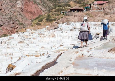 Salines à Salinas.Un ouvrier porte du sel le long des terrasses. Banque D'Images