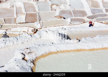 Salines à Salinas.Un ouvrier porte du sel le long des terrasses. Banque D'Images