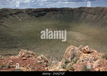 Vue vers le bas dans Meteor Crater près de Winslow dans le nord de l'Arizona, États-Unis, montrant la roche de grès renversé, superposé autour du bord. Banque D'Images