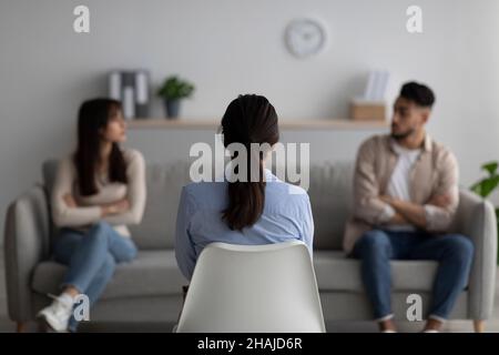 Psychologue féminine donnant une séance de thérapie pour quarreing couple moyen-oriental, les aidant avec le conflit, vue arrière Banque D'Images