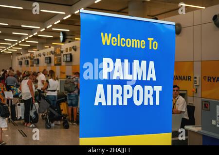 Palma, Espagne - 25 septembre 2019 : grande bannière de bienvenue bleue et blanche à l'aéroport de Majorque, passagers flous attendant aux comptoirs d'enregistrement backgrou Banque D'Images