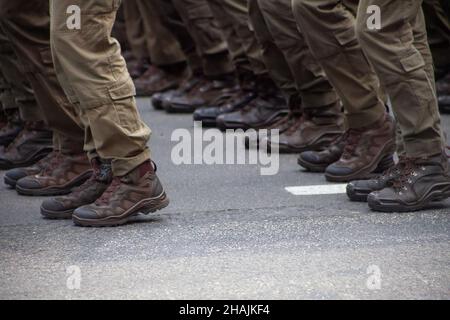 Mise au point sélective.Flou de mouvement.Chaussures militaires modernes sur les soldats.Un soldat en uniforme marche dans la parade.Les gens dans la foule.Chaussures sur le pied. Banque D'Images