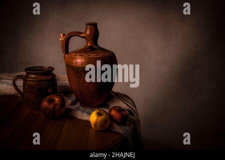 Encore la vie avec deux vieux bols à eau et trois pommes et un tissu sur la table.Art et peintures à l'huile concept.Avec espace de copie. Banque D'Images