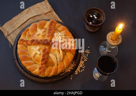 Gâteau serbe à la slava avec vin et bougie.Kolač Slavski.Pain décoratif pour la fête traditionnelle. Banque D'Images