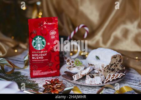 Kiev, Ukraine - 11 décembre 2021 : café starbucks esthétique dans un paquet de fête rouge avec un bâton de cône de bonbon de tasse.Stollen de Noël, biscuits et chocola Banque D'Images