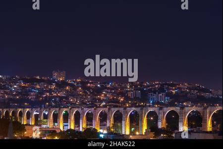 Le viaduc de la ville de Queretaro et ses gratte-ciel la nuit, au Mexique. Banque D'Images