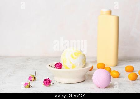 Composition avec bombes de bain, kumquat et fleurs de rose séchées sur fond clair Banque D'Images