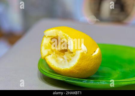 sur une assiette verte se trouve un citron pressé pendant la cuisson ou pour préparer l'assaisonnement, foyer sélectif Banque D'Images