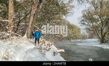 Un homme âgé fait de la randonnée le long de la rivière poudre à fort Collins, Colorado - paysage d'automne brumeux avec une neige fraîche Banque D'Images