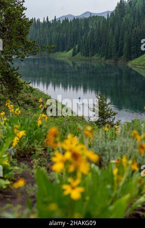 7/14/21 - Crested Butte, Colorado - Une femme montre comment faire des stands et du yoga sur un paddle board. Banque D'Images