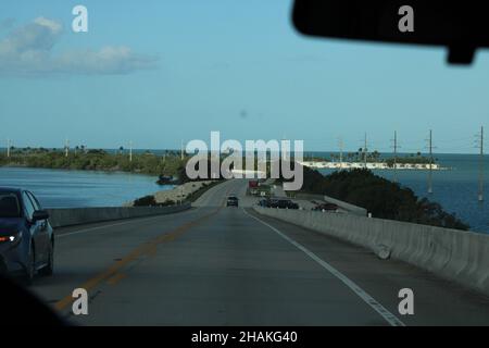 Voiture en descendant le pont de sept kilomètres, avec les Florida Keys en arrière-plan et l'eau bleue du golfe du Mexique Banque D'Images
