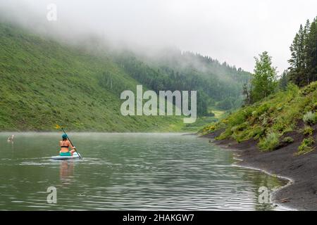 7/14/21 - Crested Butte, Colorado - Une femme montre comment faire des stands et du yoga sur un paddle board. Banque D'Images