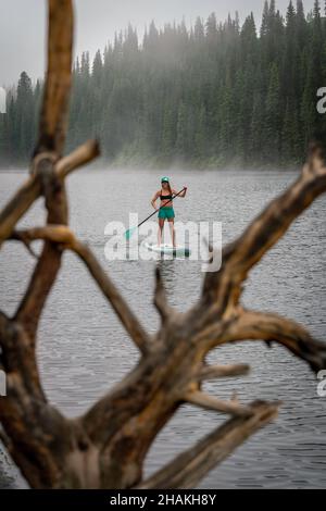 7/14/21 - Crested Butte, Colorado - Une femme montre comment faire des stands et du yoga sur un paddle board. Banque D'Images