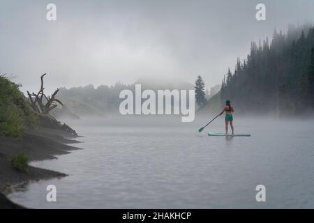 7/14/21 - Crested Butte, Colorado - Une femme montre comment faire des stands et du yoga sur un paddle board. Banque D'Images