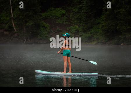 7/14/21 - Crested Butte, Colorado - Une femme montre comment faire des stands et du yoga sur un paddle board. Banque D'Images