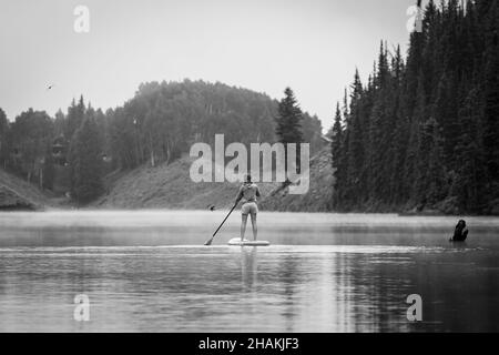 7/14/21 - Crested Butte, Colorado - Une femme montre comment faire des stands et du yoga sur un paddle board. Banque D'Images