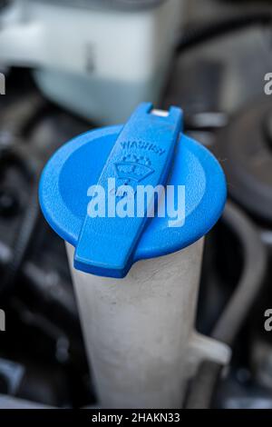 Entretien automobile.Bouchon de liquide de lave-glace de couleur bleue dans le compartiment moteur de la voiture. Banque D'Images