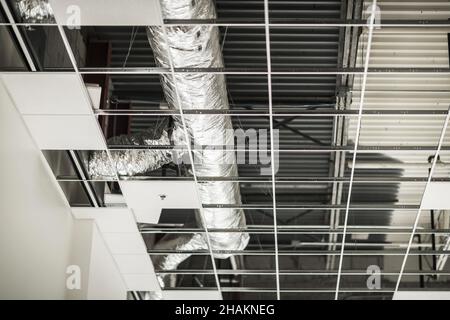 Installation de plafond CVC pour bâtiments commerciaux.Conduit d'alimentation en air et de climatisation à l'intérieur d'un grand entrepôt. Banque D'Images