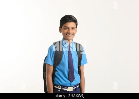 Garçon d'école indienne debout sur fond blanc. Banque D'Images