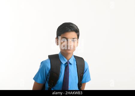 Garçon d'école indienne debout sur fond blanc. Banque D'Images