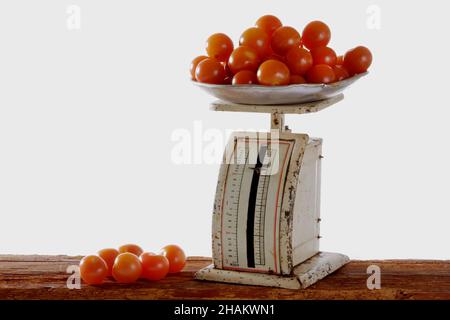 tomates sur de vieilles balances métalliques sur des poutres en bois, isolées Banque D'Images