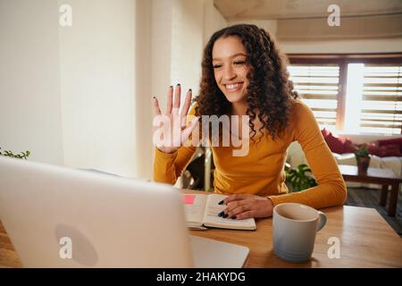 Femme d'affaires d'Amérique africaine agitant sur un ordinateur portable lors d'un appel professionnel avec des clients Banque D'Images