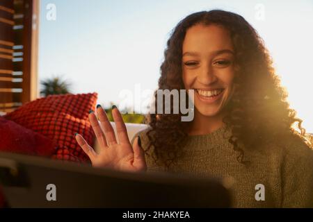 Femme afro-américaine agitant sur une tablette numérique lors d'un appel vidéo avec des amis Banque D'Images