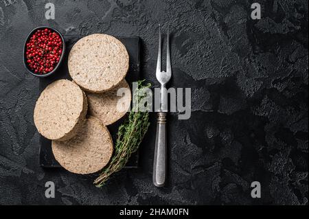 Côtelettes de burgers non cuites à base de viande végétale, viandes végétaliennes crues.Arrière-plan noir.Vue de dessus.Copier l'espace Banque D'Images