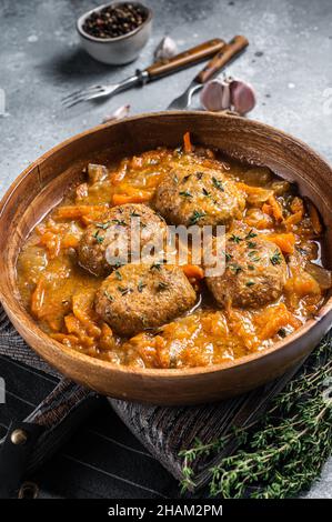 Escalopes ou boulettes de poisson avec thon dans la sauce tomate.Arrière-plan gris.Vue de dessus Banque D'Images