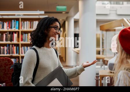 Étudiants utilisant l'assistant vocal dans la bibliothèque Banque D'Images